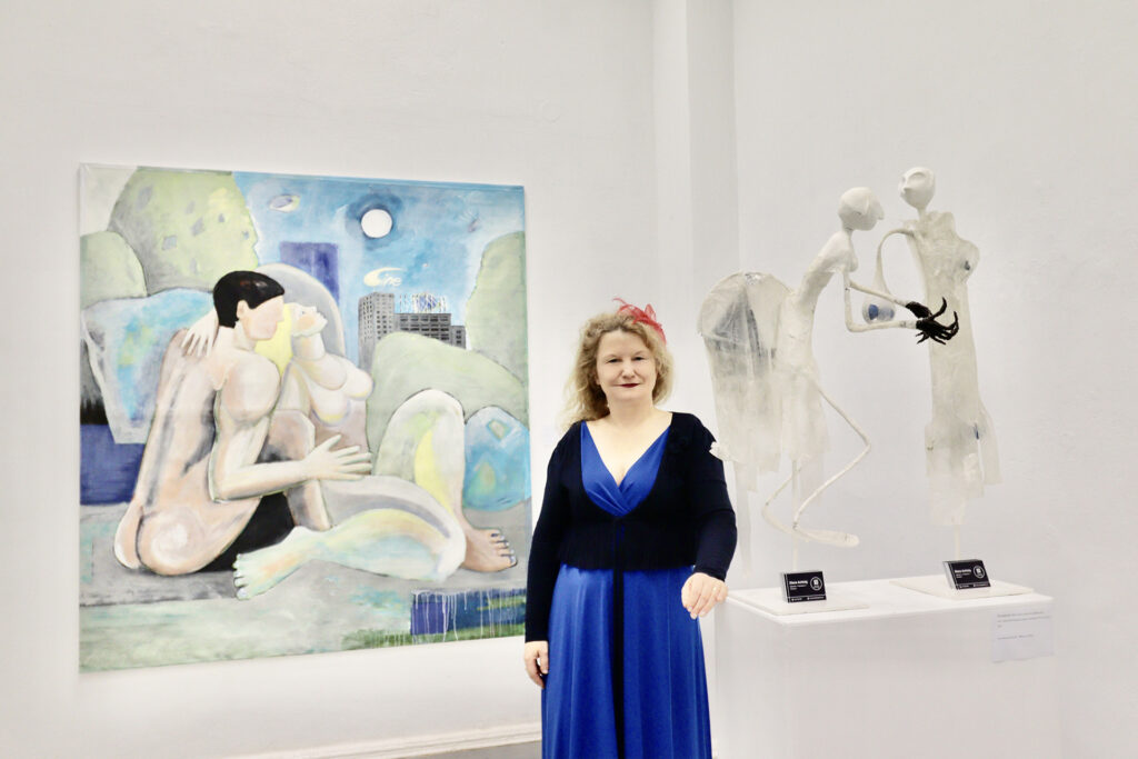 Die Galeristin und Künstlerin Diana Achtzig steht vor ihren Kunstwerken